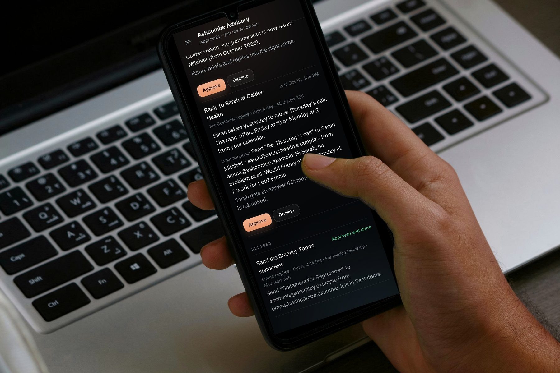 A phone held over a laptop showing PelQi Work's Approvals: a reply to a client waiting for approval, with Approve and Decline